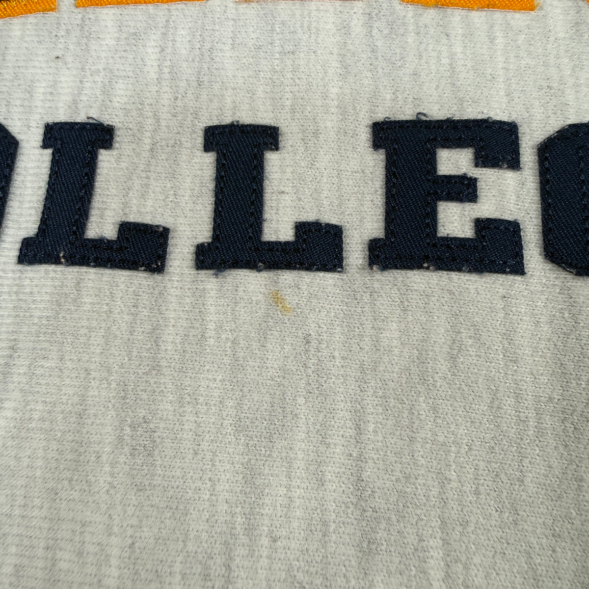 ダメージ COLLEGE の下のオレンジ色の小さなシミ