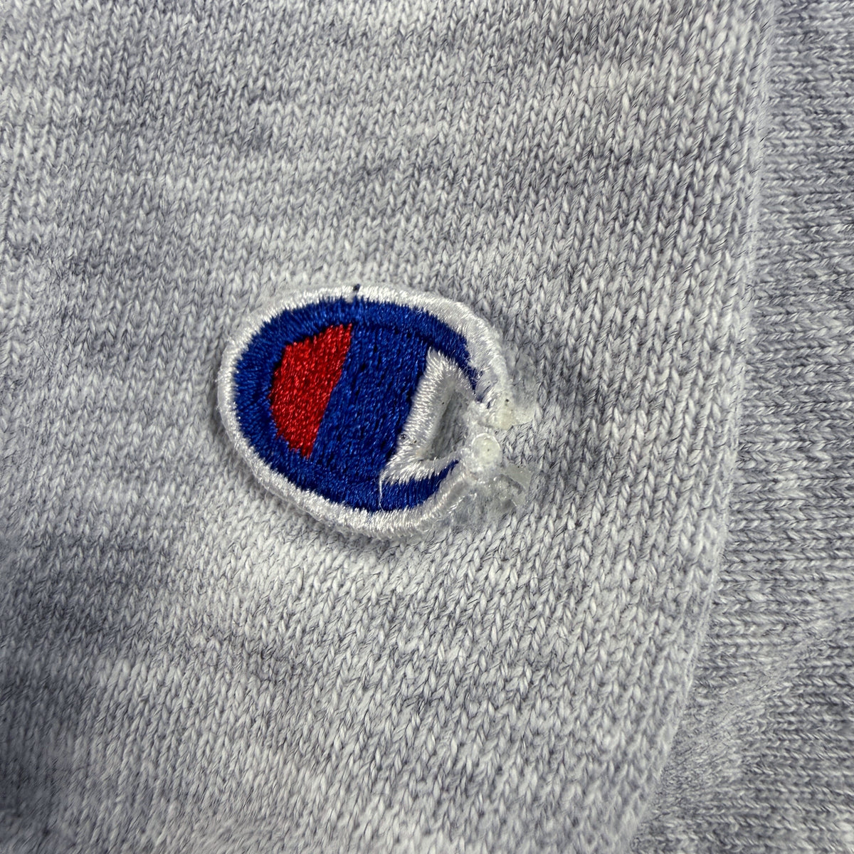 ダメージ 左袖 Cロゴ刺繍の縁のほつれ